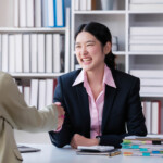 portrait young asian woman interviewer and interviewee shaking hands for a job interview .business people handshake in modern office. greeting deal concept