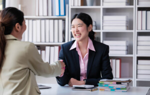 portrait young asian woman interviewer and interviewee shaking hands for a job interview .business people handshake in modern office. greeting deal concept