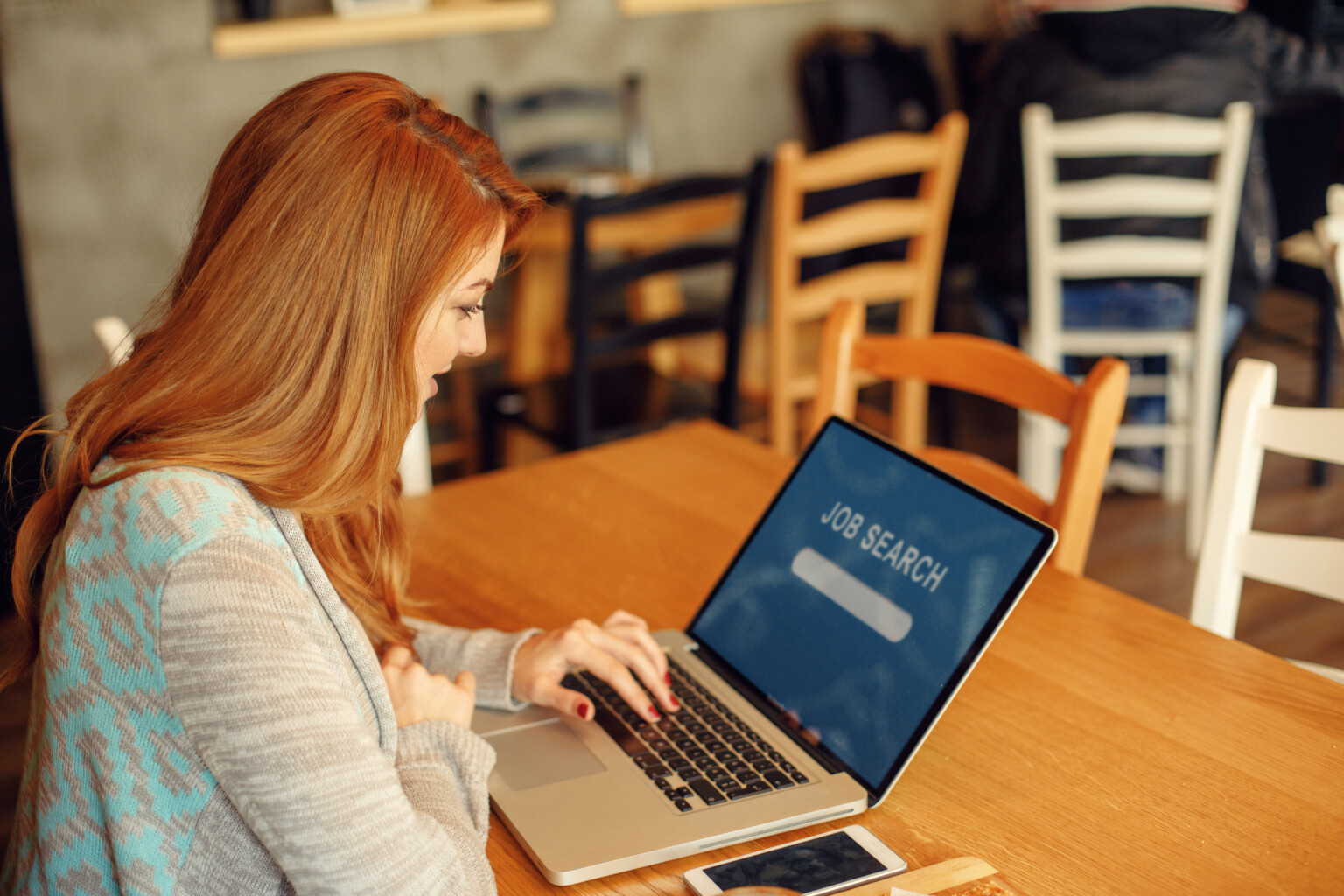 young woman searching job online in cafe
